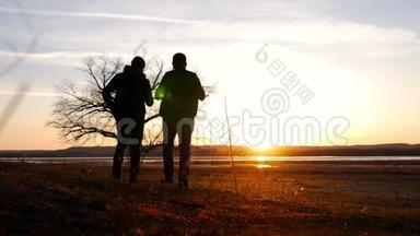 两个朋友夕阳西下<strong>往前走</strong>，探险旅行的概念，肩上背着一个背包